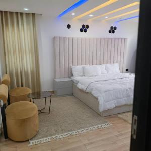 ラゴスにあるTop Loft 3bed Penthouse Viのベッドとテーブルと椅子のある寝室 +73枚の写真