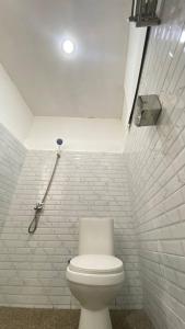 bagno con servizi igienici e parete di mattoni bianchi di Rinjani Edelweis Homestay a Tetebatu