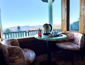 a table with a tea kettle in a room with a window at The Kufri Hills in Kūfrī +5 photos