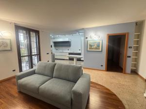 a living room with a couch and a kitchen at Giulia's Penthouse in Cernusco sul Naviglio