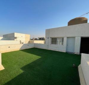 un bâtiment avec une cour avec de l'herbe verte dans l'établissement مدينتي القاهرة الجديدة, à Madinaty