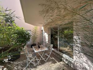 a patio with two chairs and a table in front of a building at Appartement neuf à 2 pas du port de Vannes in Vannes