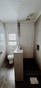 a white bathroom with a toilet and a sink at Livingwaters Self-Catering Accommodation in Ermelo +47 photos