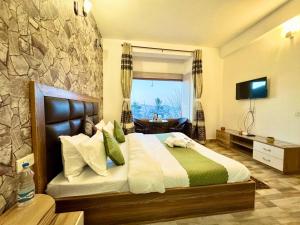 a bedroom with a large bed with a stone wall at The Kufri Hills in Kūfrī