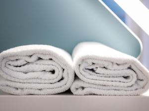 a stack of towels sitting on a table at ibis budget Fribourg in Fribourg +63 photos