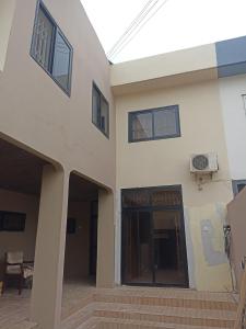 にあるAdelpha Properties,Abelenkpe accraのドアとバスケットボールのゴールがある建物