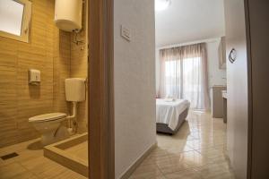 a bathroom with a toilet and a bed in a room at Hotel Apartments More in Neum +17 photos