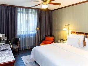 a hotel room with a large bed and a chair at Mercure Hotel Frankfurt Airport Langen in Langen +142 photos
