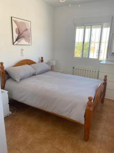 a bedroom with a large bed with white sheets at Casa iris in San Miguel de Salinas +34 photos