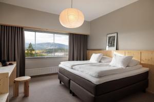 une chambre avec un grand lit avec une grande fenêtre dans l'établissement Ski Resort & Hotel Pikku-Syöte, à Syöte