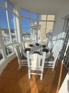 a dining room with a table and white chairs at Casa iris in San Miguel de Salinas