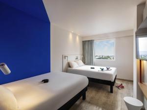 a hotel room with two beds and a window at ibis budget Aguascalientes Norte in Aguascalientes