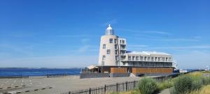 a building with a lighthouse next to the water at Suite Vuurtoren Zeeland in Scherpenisse