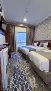 a hotel room with three beds and a television at فندق البارون الذهبي in Az Zāhir +18 photos
