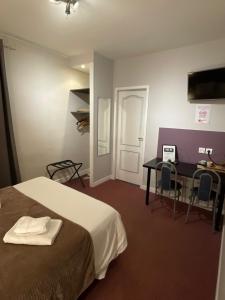 a hotel room with a bed and a desk and a table at Le Logis Saumur in Saumur