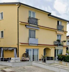 a yellow building with windows and a balcony at Vivere in Slovenia in Plavje