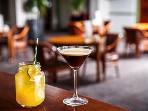 a cocktail and a drink on a table at Mercure Birmingham West Hotel in West Bromwich