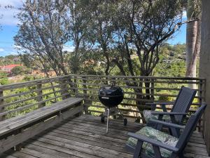 a grill and two chairs on a wooden deck at Cottage on Salvia in East London