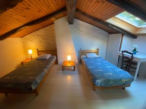 two beds in a room with a table and a table sidx sidx sidx at Gîte de Linas in Comprégnac
