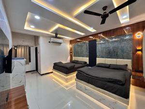 a bedroom with two beds and a ceiling fan at Maa Madhvadi Hotel & Restaurant in Mātānomadh