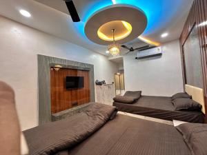 a living room with two beds and a tv at Maa Madhvadi Hotel & Restaurant in Mātānomadh