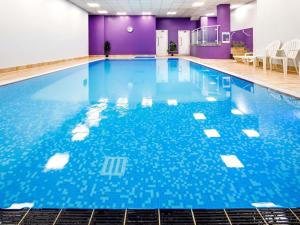 a large swimming pool with blue water at Mercure Telford Centre Hotel in Telford