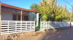 une clôture blanche devant une maison dans l'établissement Departamento Virgen del Valle, à Fiambala