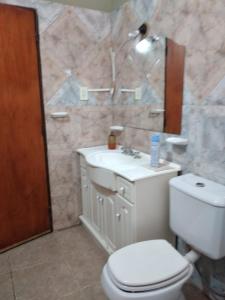 une salle de bain avec des toilettes blanches et un lavabo dans l'établissement Departamento Virgen del Valle, à Fiambala