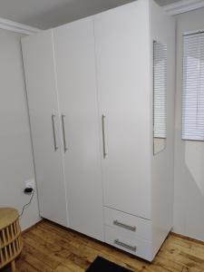 a large white cabinet in a room with a table at The Man Cave Extension in Sabie