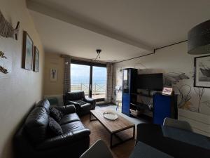 ein Wohnzimmer mit Sofa und Tisch in der Unterkunft 2 Chambres face à la mer En terrasse La Naturelle in Wimereux