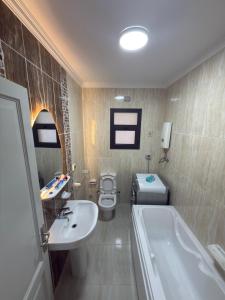 ein Badezimmer mit Badewanne, Toilette und Waschbecken in der Unterkunft مدينتي القاهرة الجديدة in Madinaty