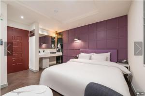 ソウルにあるHotel YEOWOOJAMの紫の壁のベッドルーム1室(大きな白いベッド1台付)