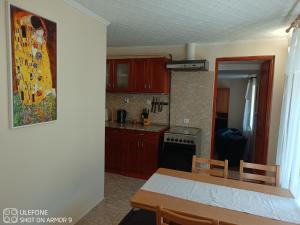 a kitchen with wooden cabinets and a table and a dining room at Tokaj-Wine Guesthouse and Spa in Mád