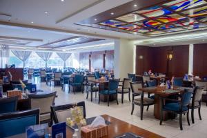 a restaurant with tables and chairs and a colorful ceiling at Sumou Al Khobar Corniche in Al Khobar