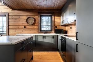 a kitchen with wooden walls and a wooden ceiling at Rödräven Familjevänligt fjällhus i Idre in Idre +37 photos