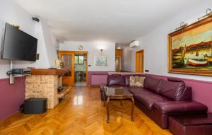 a living room with a purple couch and a fireplace at Holiday Home Villa Laura - Krk by Villas Guide in Krk