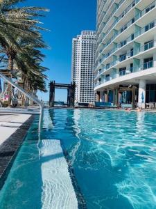 a large swimming pool in front of a building at Beautiful Beach front condo with Top Amenities in Hollywood