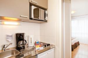 - une cuisine avec un évier et un comptoir dans l'établissement Séjours & Affaires Paris-Vitry, à Vitry-sur-Seine