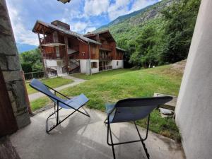 two chairs sitting on a porch in front of a building at Appartements Ski Spa & Confort Orelle-3 vallées in Orelle
