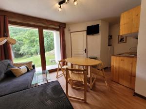 a living room with a table and a kitchen at Appartements Ski Spa & Confort Orelle-3 vallées in Orelle