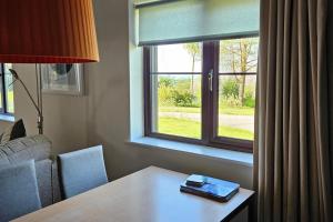 a living room with a table and a window at 2br-sleeps4-pool-freeparking-trenythonestate in Par
