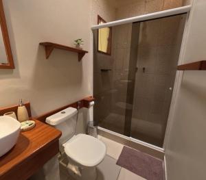 a bathroom with a shower and a toilet and a sink at Fauna in Praia do Bananal