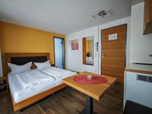 - une chambre avec un lit et une table avec une plaque de cuisson dans l'établissement Birkhofer See genießen - Aparthotel am Bodensee, à Immenstaad am Bodensee
