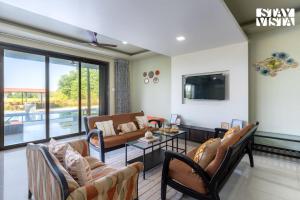 a living room with a couch and a table at StayVista at Ocean Breeze with Bonfire & Pool in Guhagar