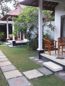 a porch with two chairs and a table at Radya Homestay in Nusa Lembongan