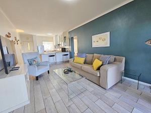 a living room with a couch and a table at Dolphin Nook 29 in Gqeberha
