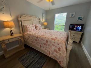 une chambre avec un lit et une télévision dans l'établissement Redfish - Updated & Roomy 1.5 Mi to Beach Full Kitchen W&D, à Bonita Springs
