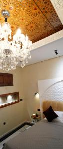 a bedroom with a chandelier and a bed at Le 146 - Art of Living in Rabat