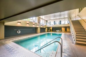 a large indoor pool with a staircase and a swimming pool at Newmark Bayview Luxury Suite in Seattle