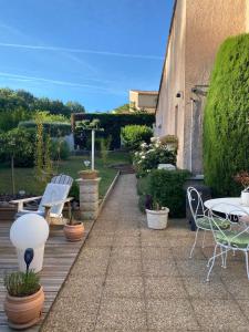 a patio with a table and chairs and plants at Escapade Au Soleil in Gréasque